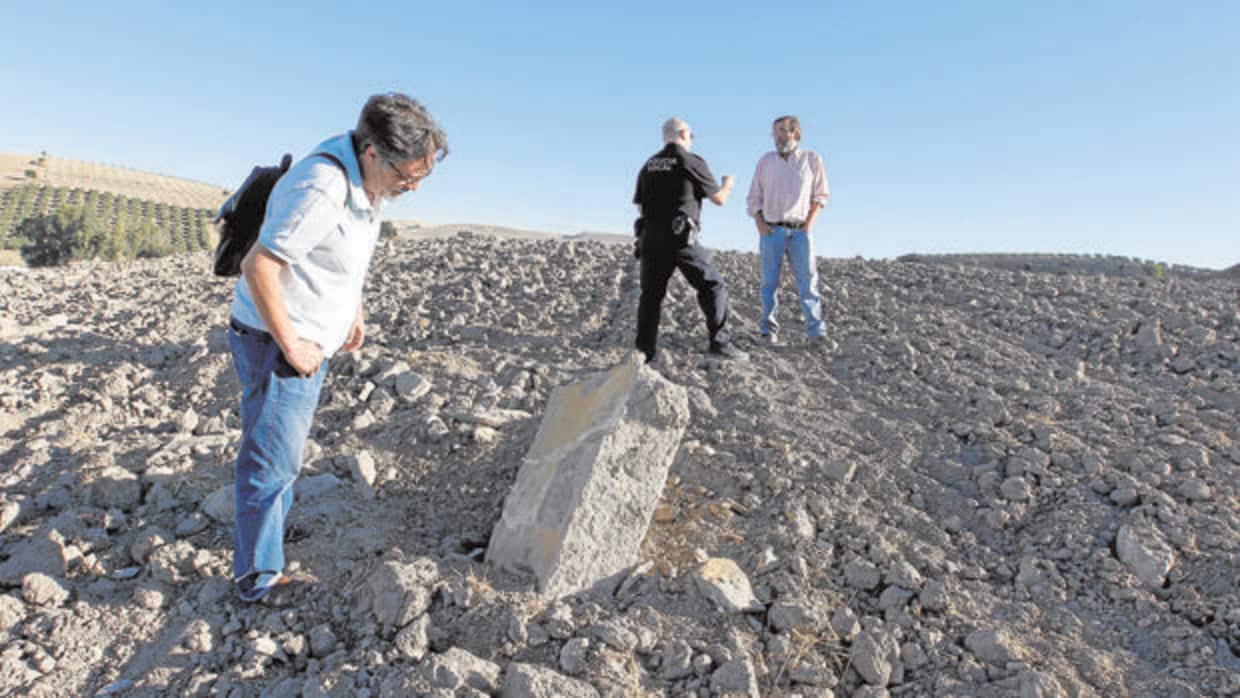 Dos arqueólogos y un policía en una zona del yacimiento de Ategua