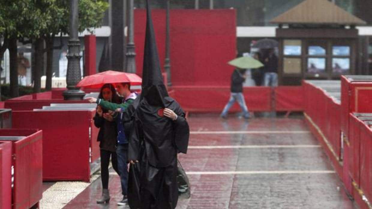 Un nazareno bajo la lluvia en la plaza de Las Tendillas de Córdoba