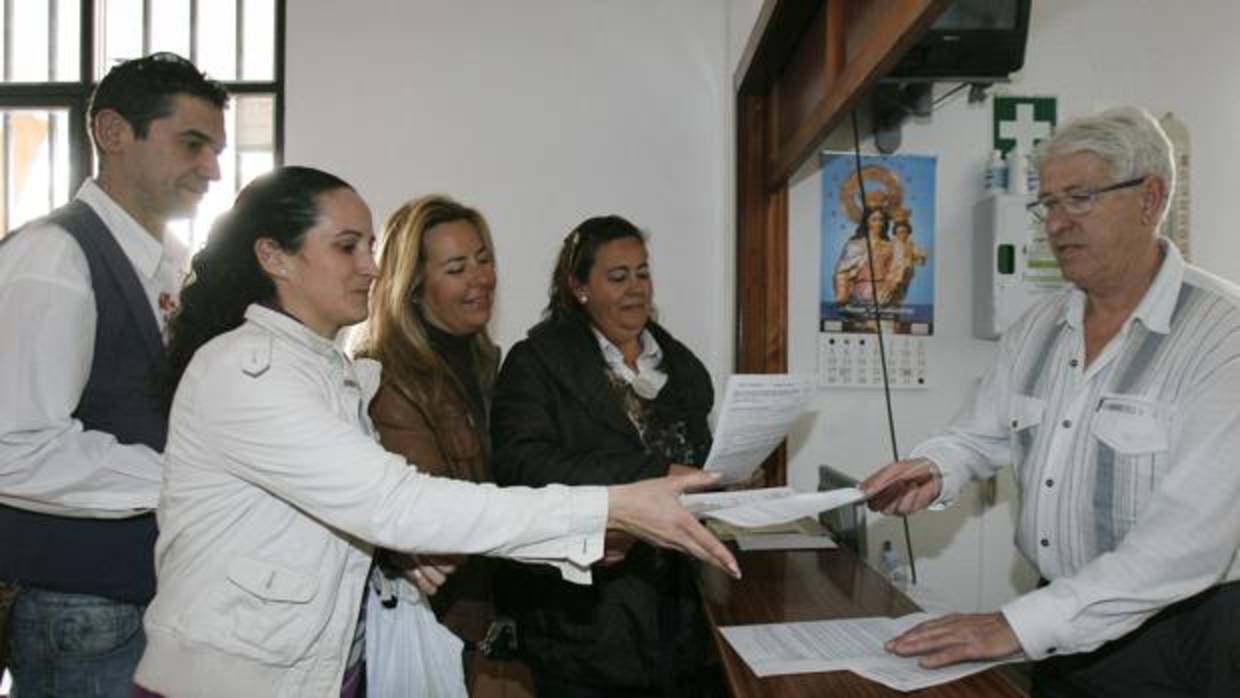 Madres y padres de alumnos entregando documentación en un colegio