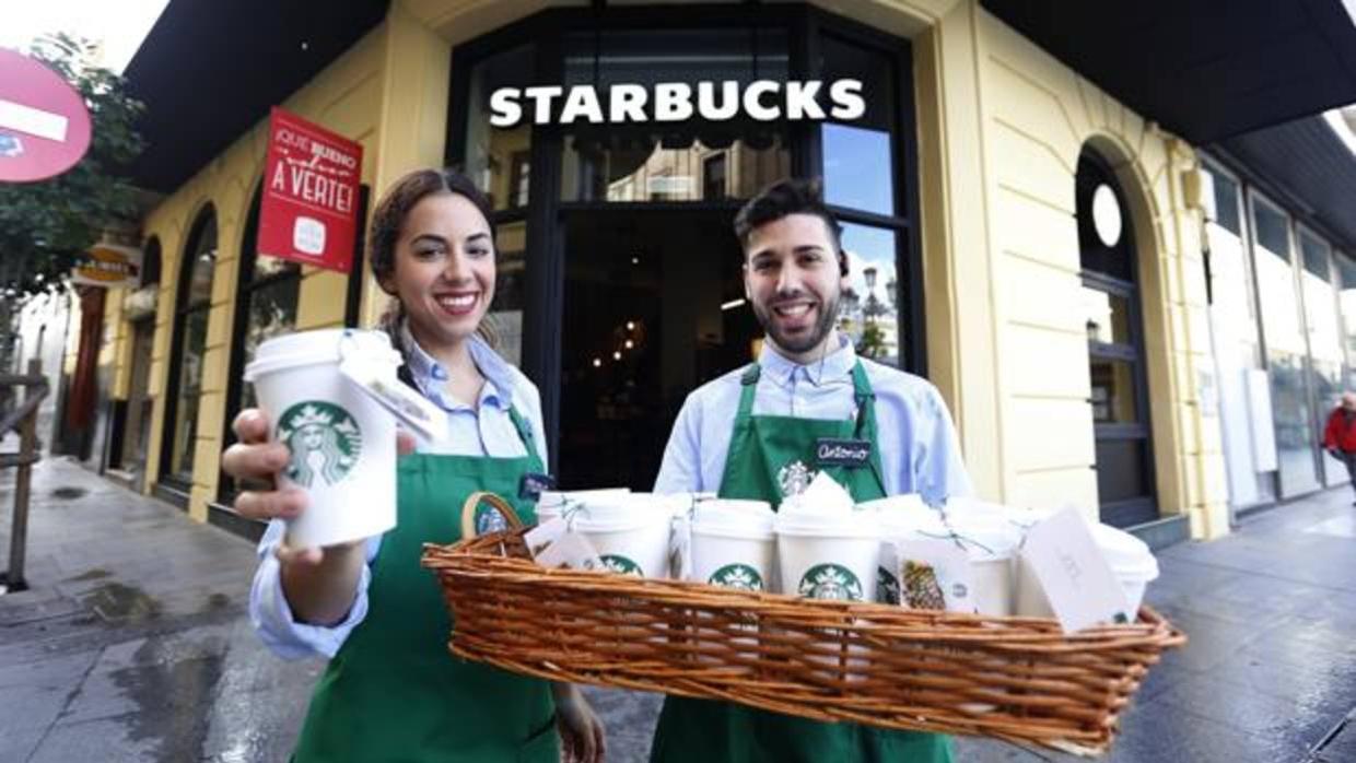 Dos trabajadores de Starbucks en la puerta de la cafetería