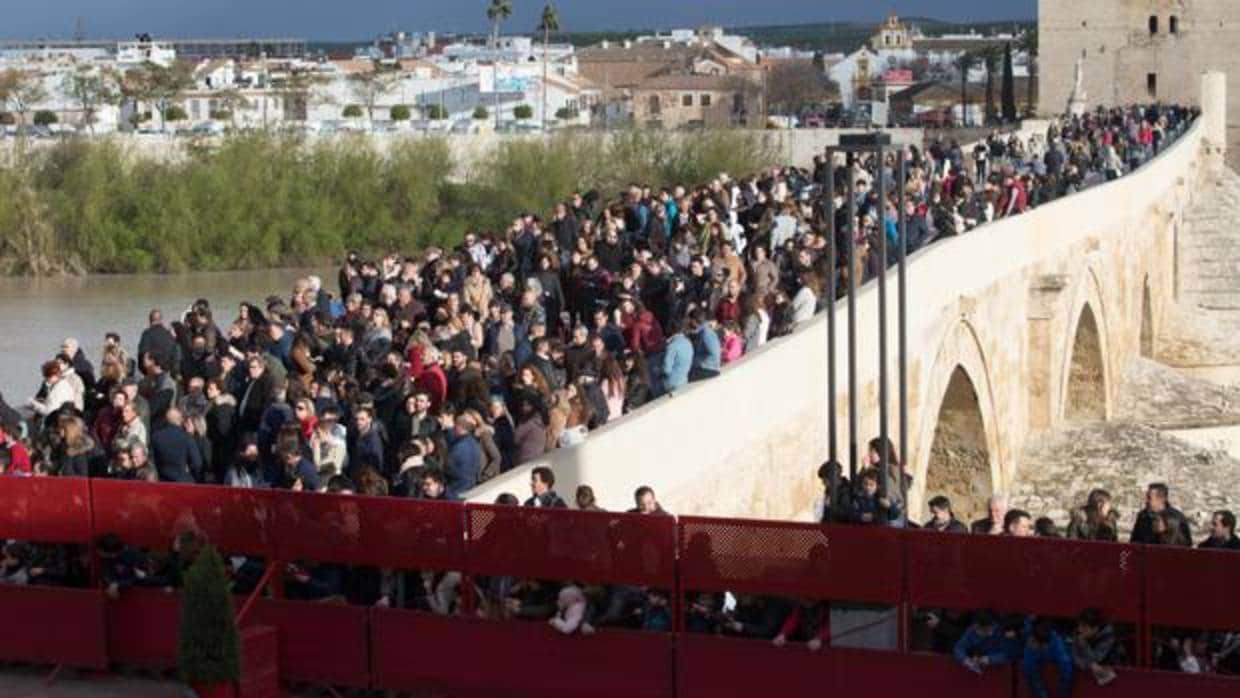 Público tras las vallas de la carrera oficial de la Semana Santa de Córdoba junto al Puente Romano