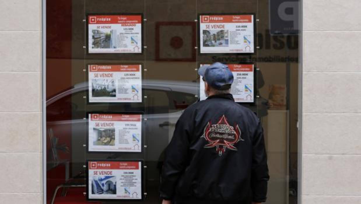 Un hombre mira los carteles de pisos en venta en una inmobiliaria del Centro de Córdoba