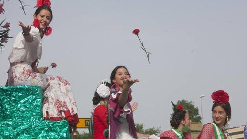 Unas jóvenes lanzan flores desde las carrozas durante la última romería de Santo Domingo