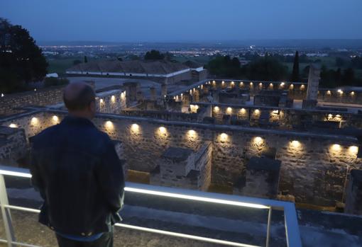 Una persona observa la ciudad califal iluminada cuando cae la noche