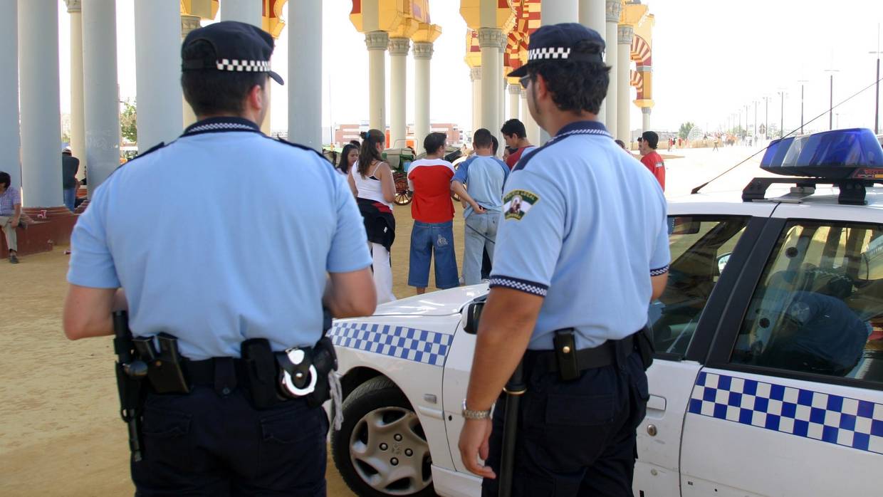 Dos agentes de la Policía Local junto a la portada de El Arenal