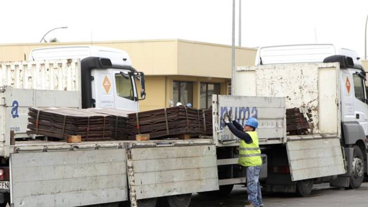 Un operario prepara un camión con carga de chapas de cobre