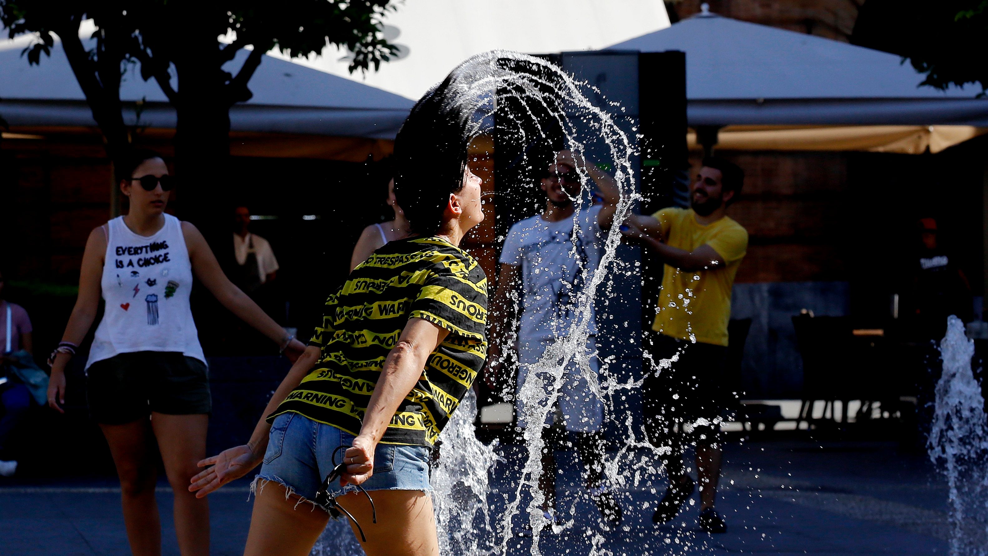 Una mujer se refresca en una fuente de Las Tendillas