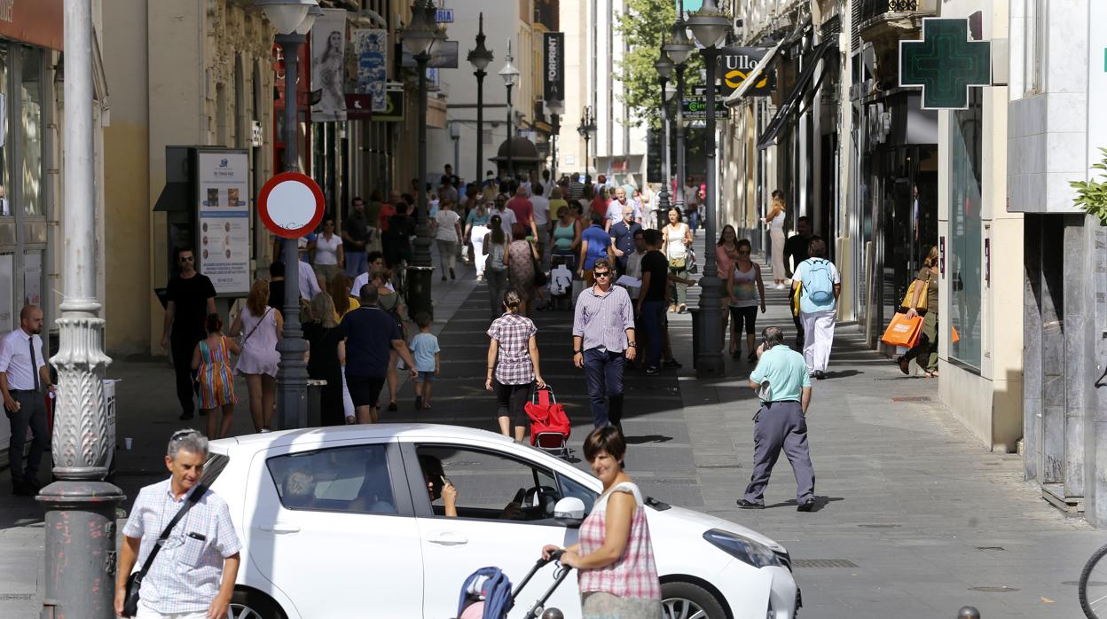 Una mujer con un bebé pasea por el centro de Córdoba junto a un hombre mayor