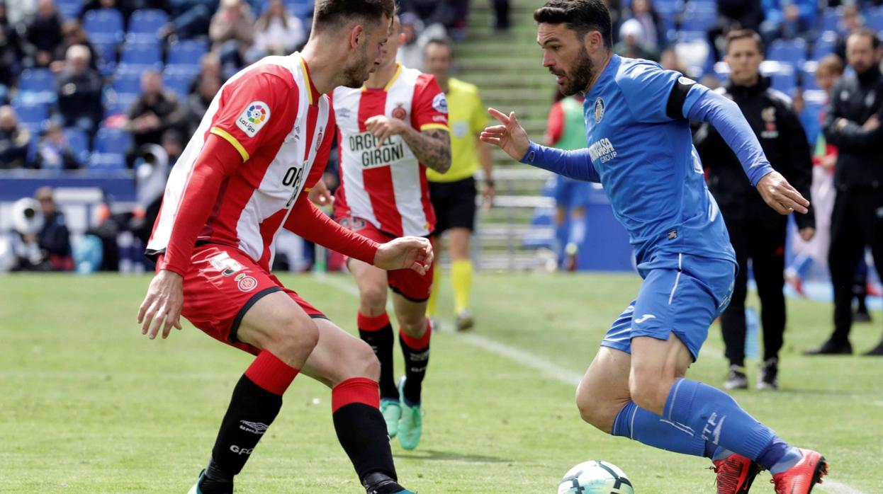 El delantero del Getafe Jorge Molina supera a un rival ante el Girona