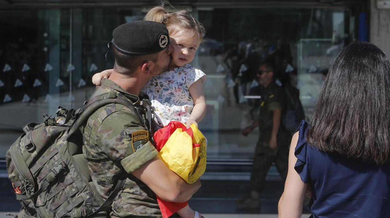 Un soldado con su hija en brazos en su retorno a casa