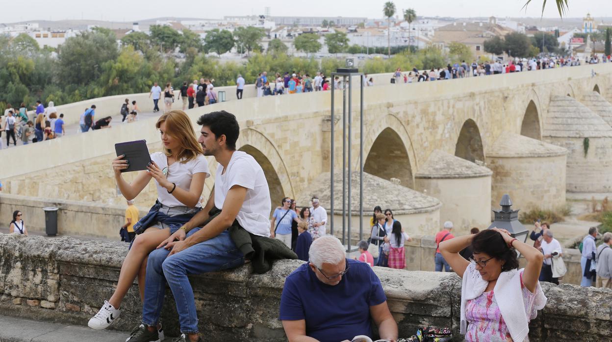 Turistas entre el Triunfo de San Rafael y el Puente Romano de Córdoba