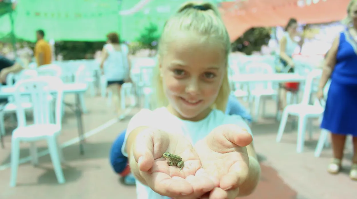 La pequeña Adriana posa con la rana ganadora, «Pepito»