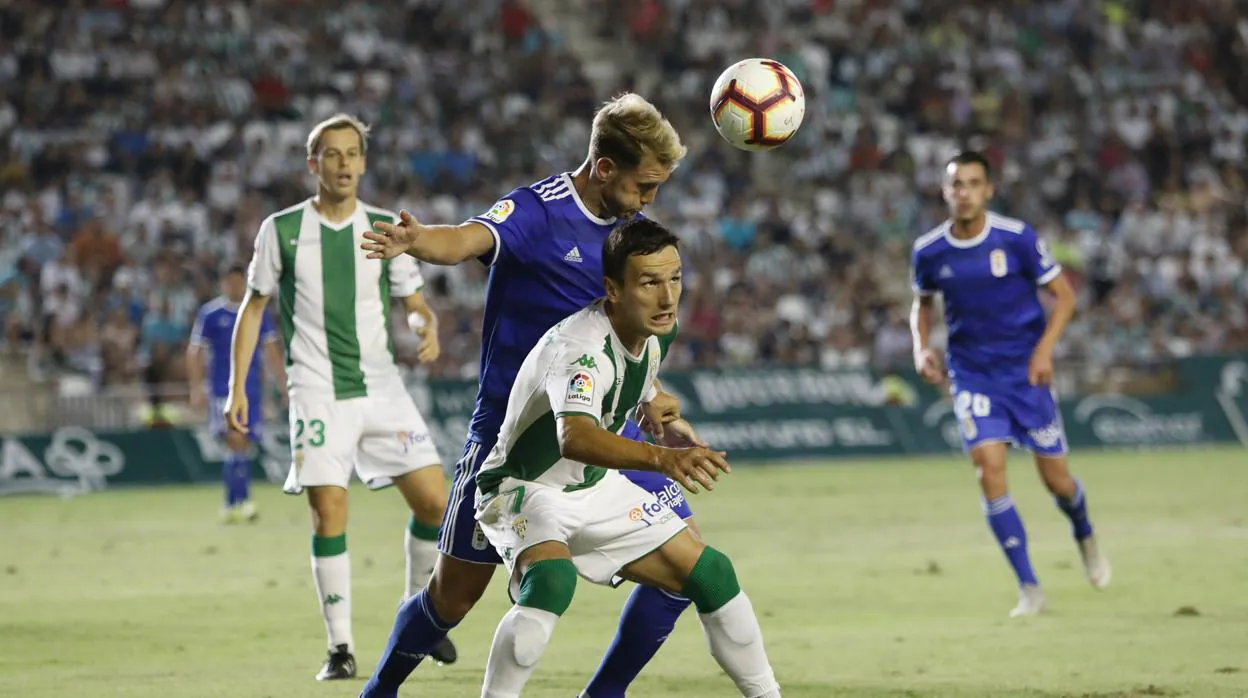 Sasa Jovanovic pelea la pelota contra el zaguero del Real Oviedo Carlos Hernández