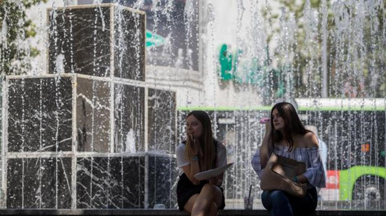 Dos jóvenes en la fuente del bulevar del Gran Capitán