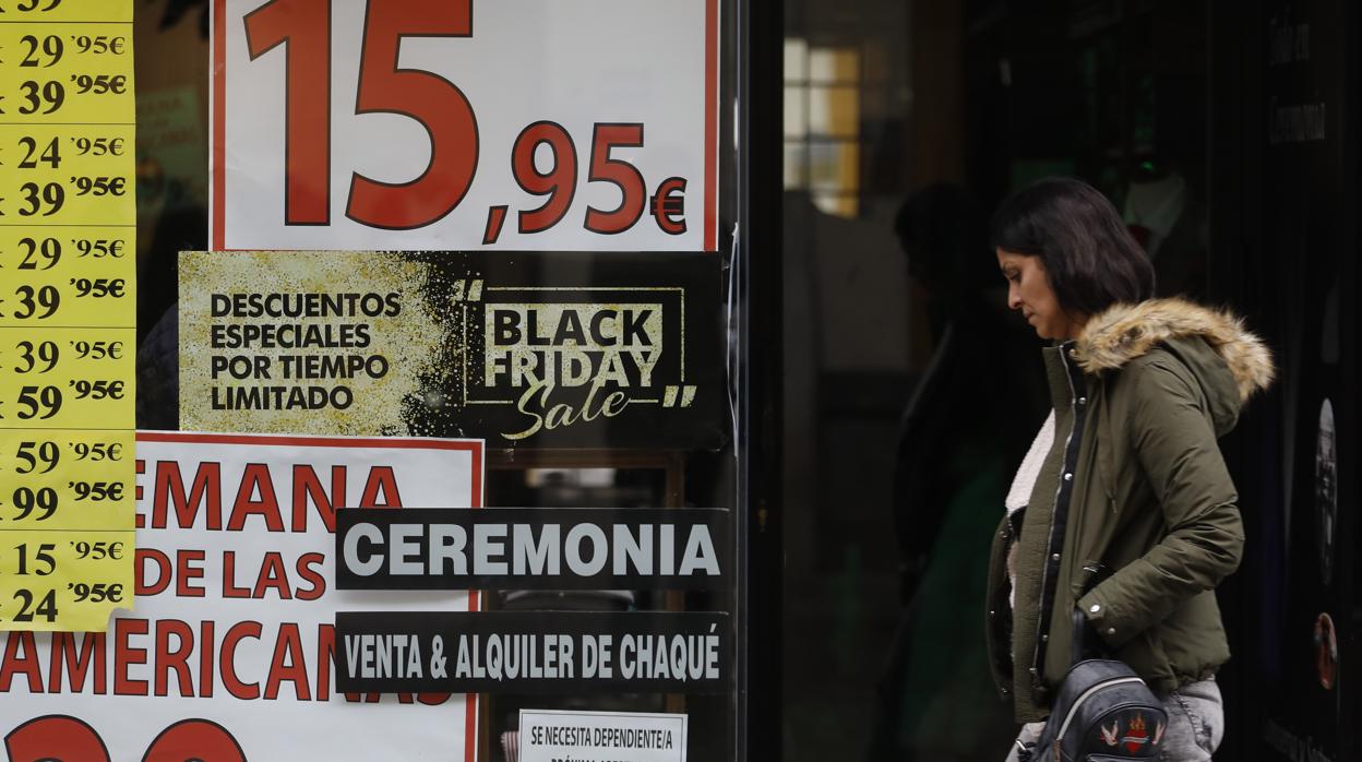 Una mujer pasa por un establecimiento que anuncia descuentos por el «Black Friday»