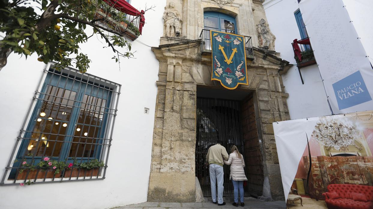 Dos personas ante la puerta principal del Palacio de Viana