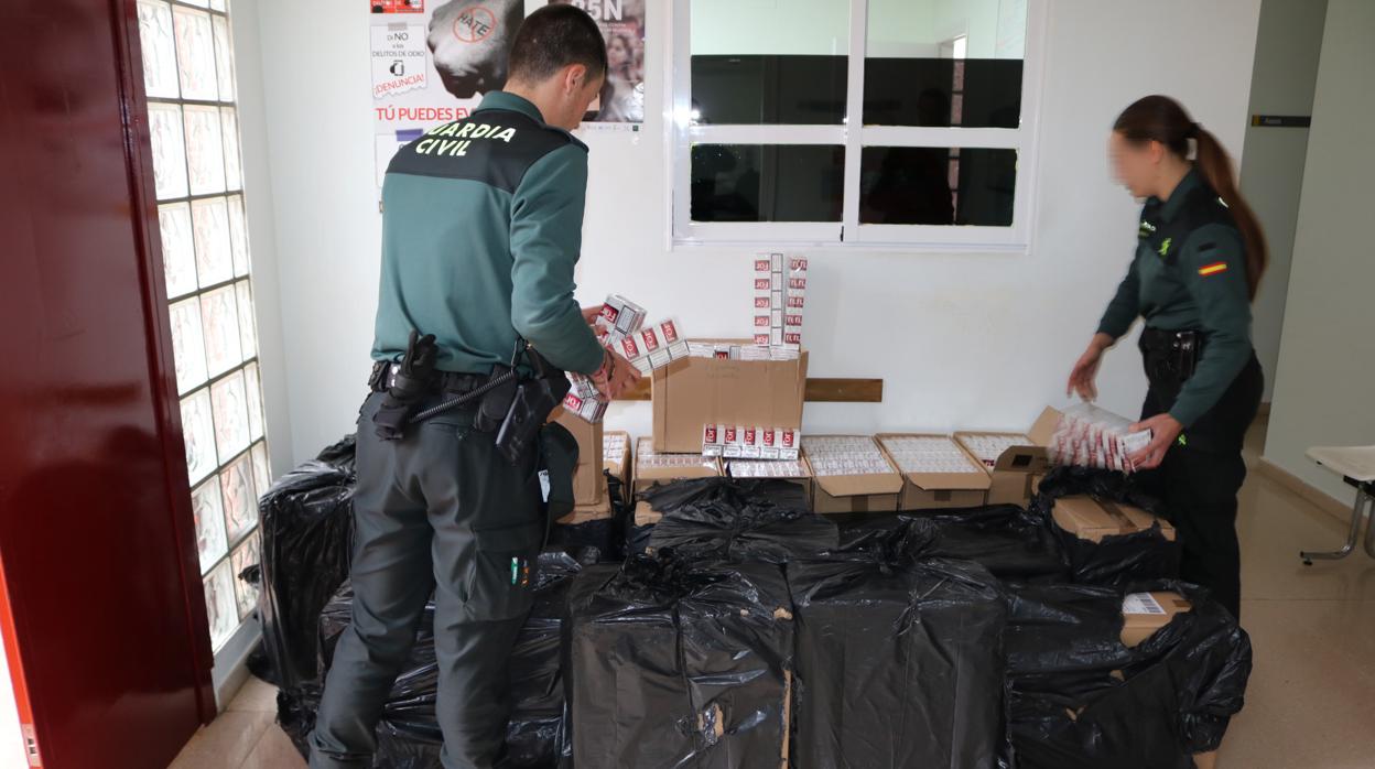 Agentes de la Guardia Civil inspeccionan la mercancía descubierta en los vehículos