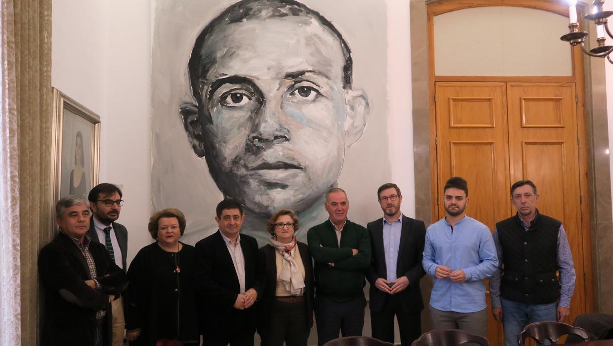 Miembros de la fundación ante un retrato de Miguel Hernández