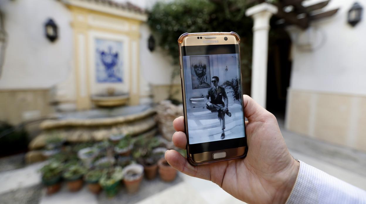 Una persona muestra la fotografía de Manolete en el mismo patio de la vivienda