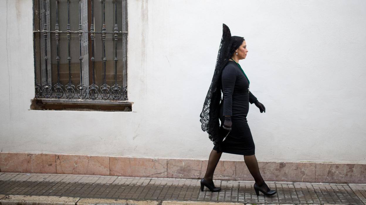 Mujer vestida de mantilla caminando por las calles de Córdoba durante la Semana Santa