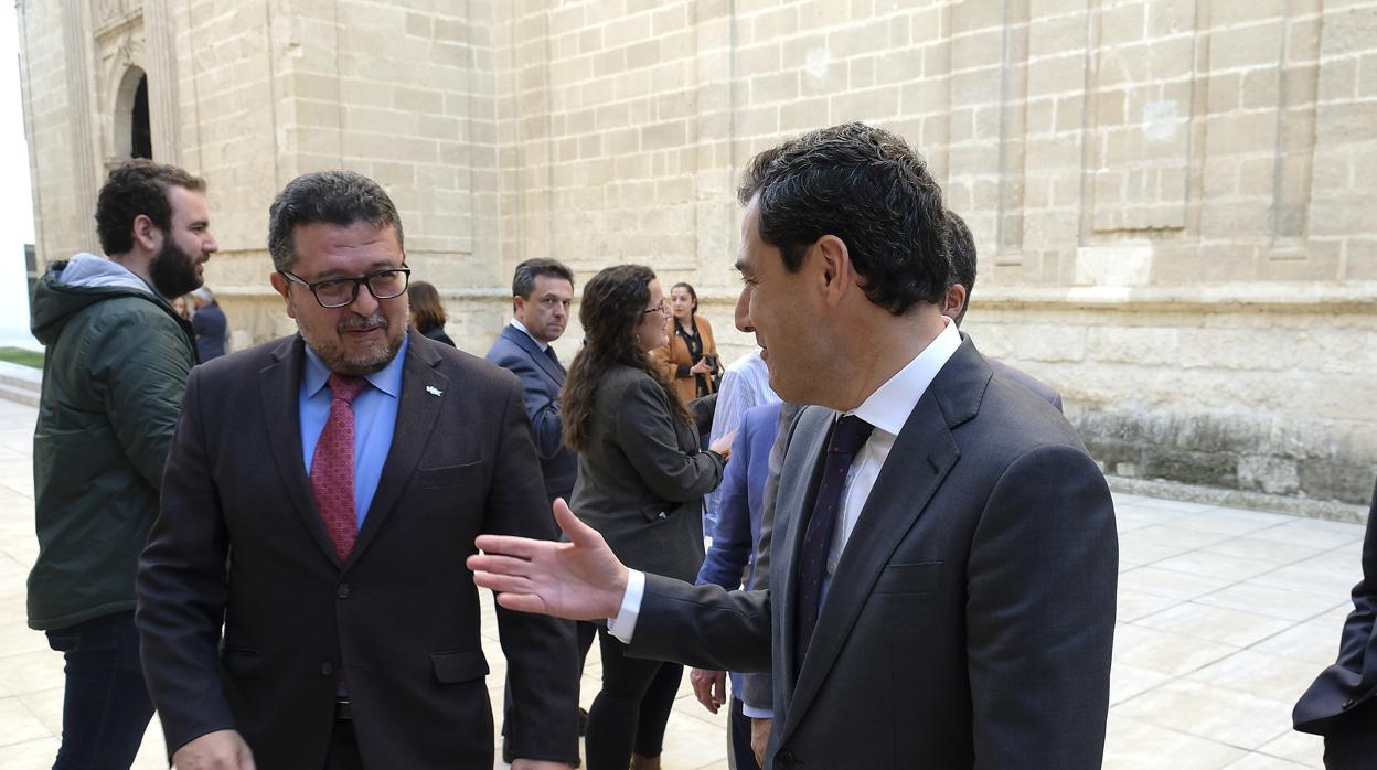 El presidente de la Junta, Juanma Moreno, tiende la mano a Francisco Serrano en el patio del Parlamento