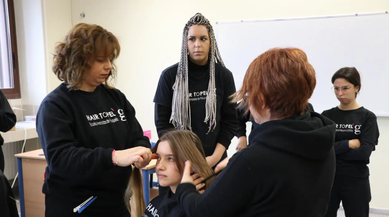 Empleados de una peluquería cortan el pelo de los jóvenes que quieran donarlo