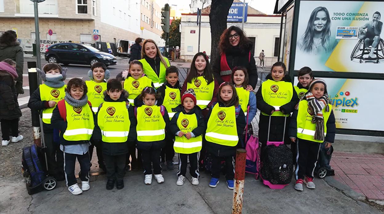 Monitoras con un grupo de alumnos equipados con chalecos relfectantes para hacer la ruta a pie