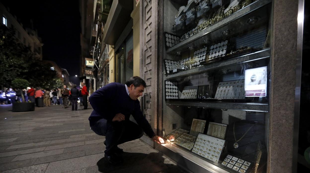 Un comerciante de Cruz Conde ilumina su escaparate durante la protesta de esta semana