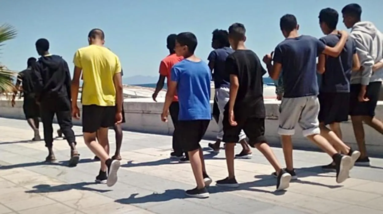 Un grupo de menores inmigrantes pasea por una playa andaluza.
