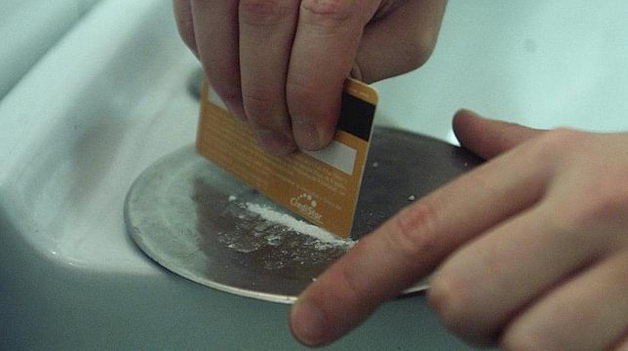 Un adicto prepara una dosis de cocaína