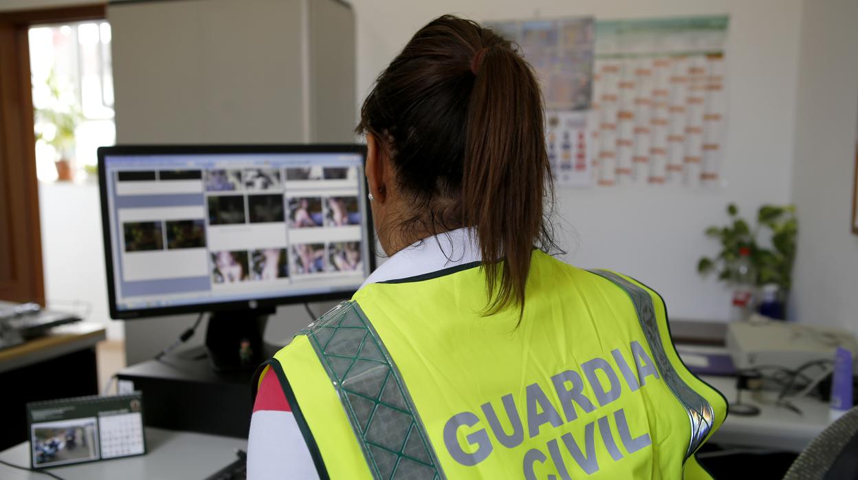 Una agente de la Guardia Civil examina material informático en la Comandancia de Córdoba