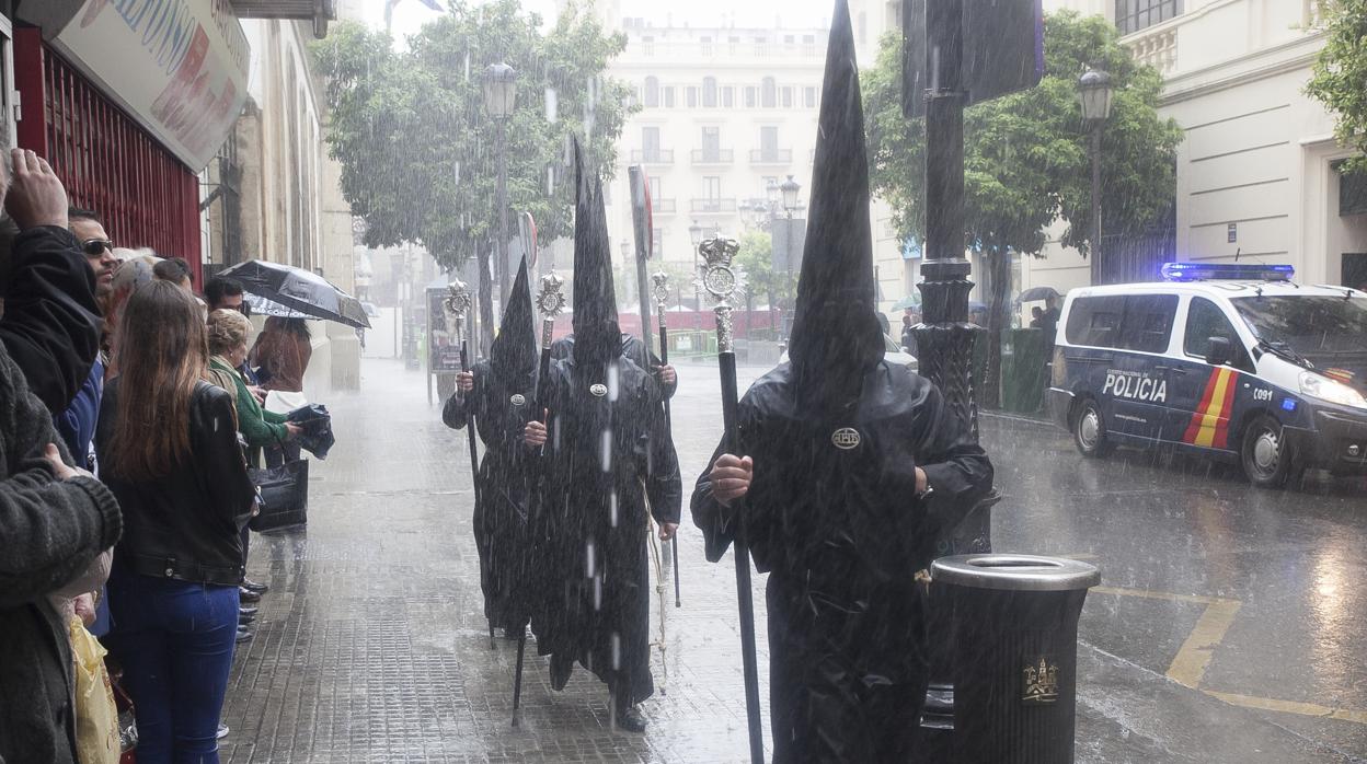 Nazarenos de la cofradía de Jesús Nazareno bajo la lluvia el Domingo de Ramos del año 2016