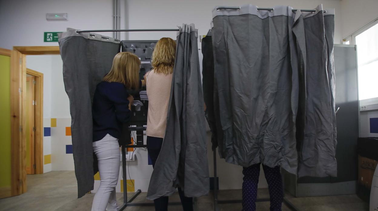 Electoras en cabinas en un colegio electoral de Sevilla en las pasadas elecciones