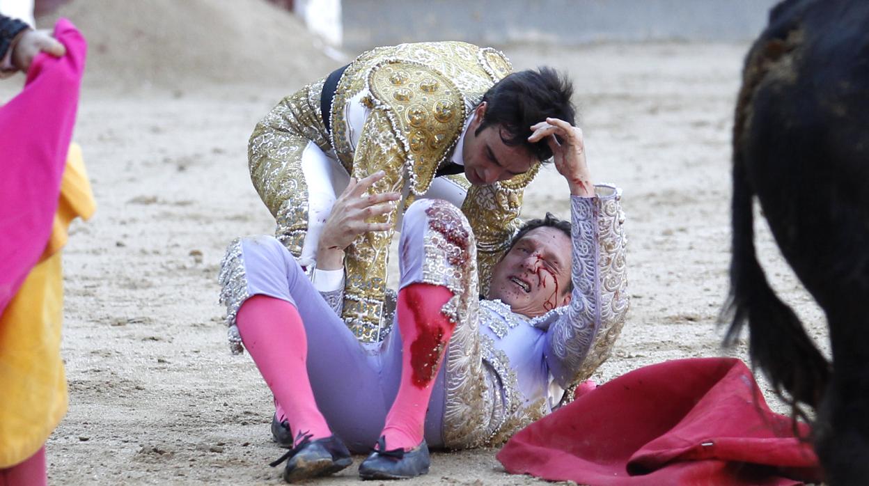 El banderillero, en el suelo, tras la cogida