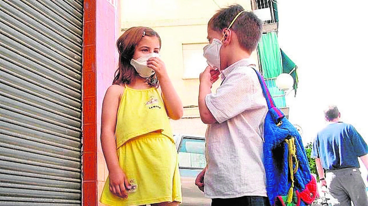 Dos niños con mascarilla camino del colegio