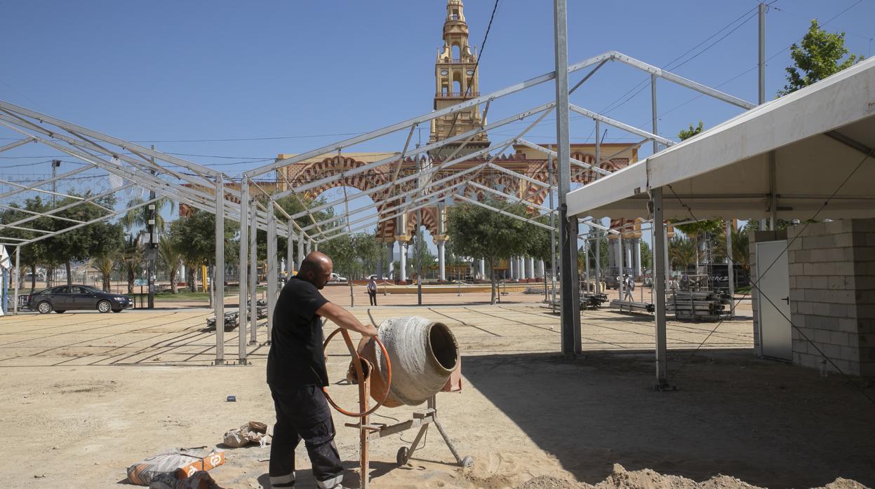 Un operario trabaja en el montaje de una caseta en el día de ayer