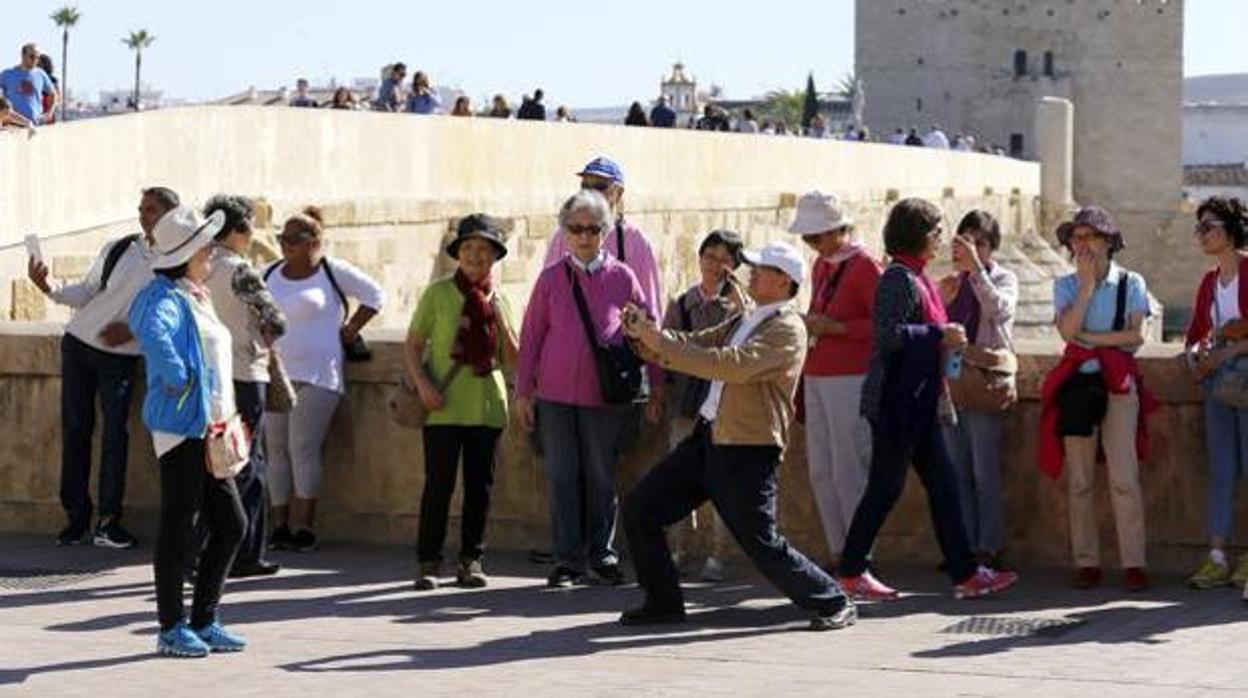 Un grupo de turistas se fotografían en el Puente Romano