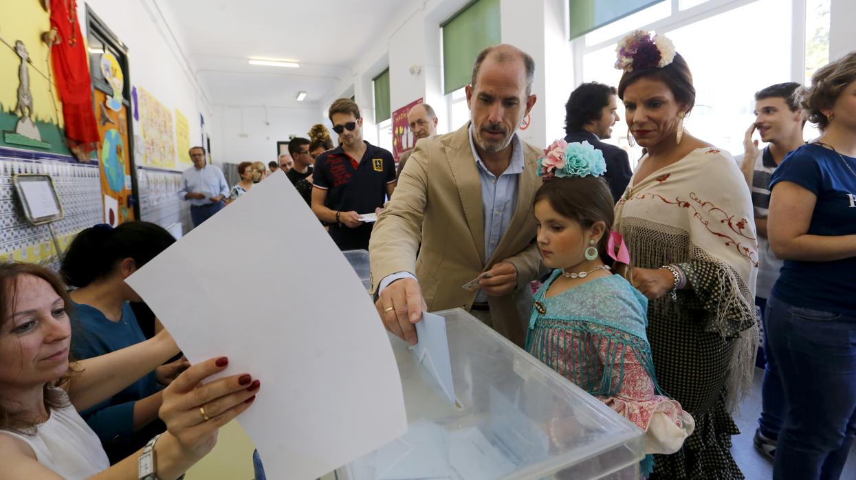 Una familia acude a votar en la urna en un colegio electoral de Córdoba