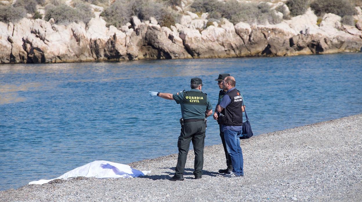 Agente s de la Guardia Civil y Servicios de Emergencia junto al cuerpo sin vida de la mujer que ha aparecido flotando en la playa de Salobreña, Granada