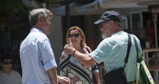 Un vecino para al alcalde por la calle para felicitarle por su nueva victoria electoral