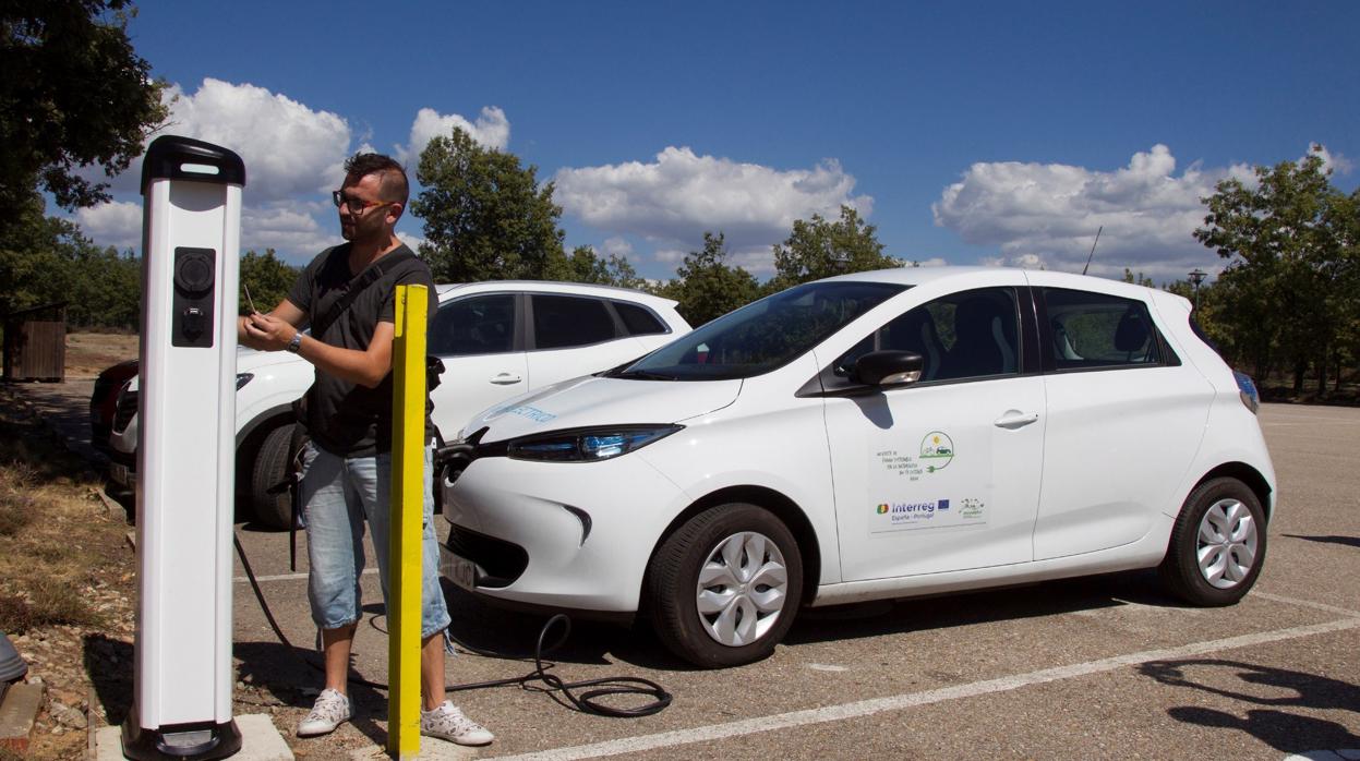 Un hombre recarga un coche eléctrico en un paraje natural de Zamora
