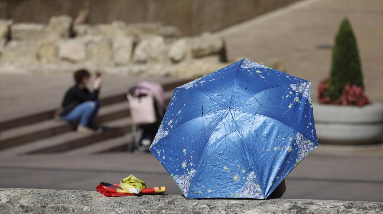 Un turista se resguarda del calor en Córdoba con una sombrilla