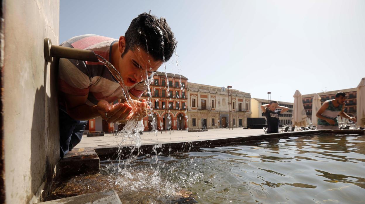 Un joven se refresca en la fuente de la plaza de la Corredera