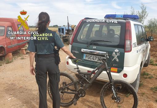 Una agente de la Guardia Civil, con una bicileta también recuperada en la operación