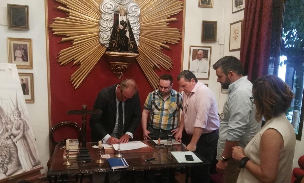 Momento de la firma entre la hermandad y la banda