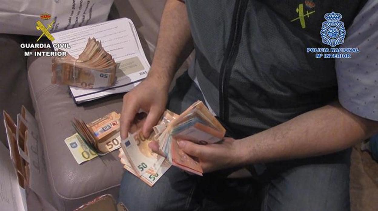Un agente de la Guardia Civil cuenta dinero requisado al grupo criminal