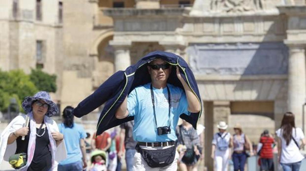 Un turista se protege del sol con una chaqueta en Córdoba