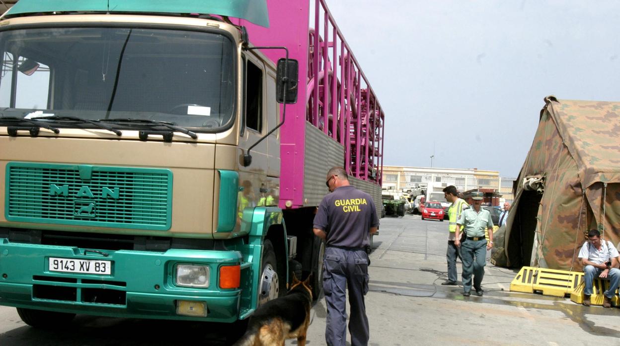 Un guardia civil junto a su perro detector investiga un camión en una imagen de archivo