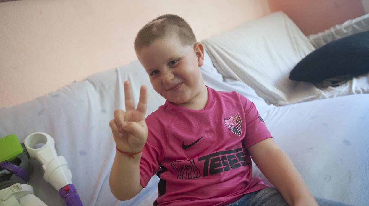 Cristian en su casa con la camiseta que le han regalado los jugadores del Málaga C. F.