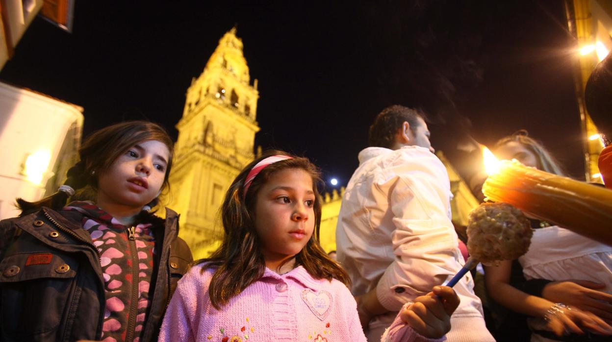 Dos niñas recogen cera en la Semana Santa de Córdoba